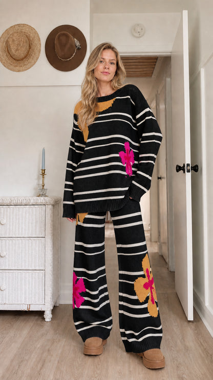 Model wearing black striped knit lounge set with contrast floral patterns