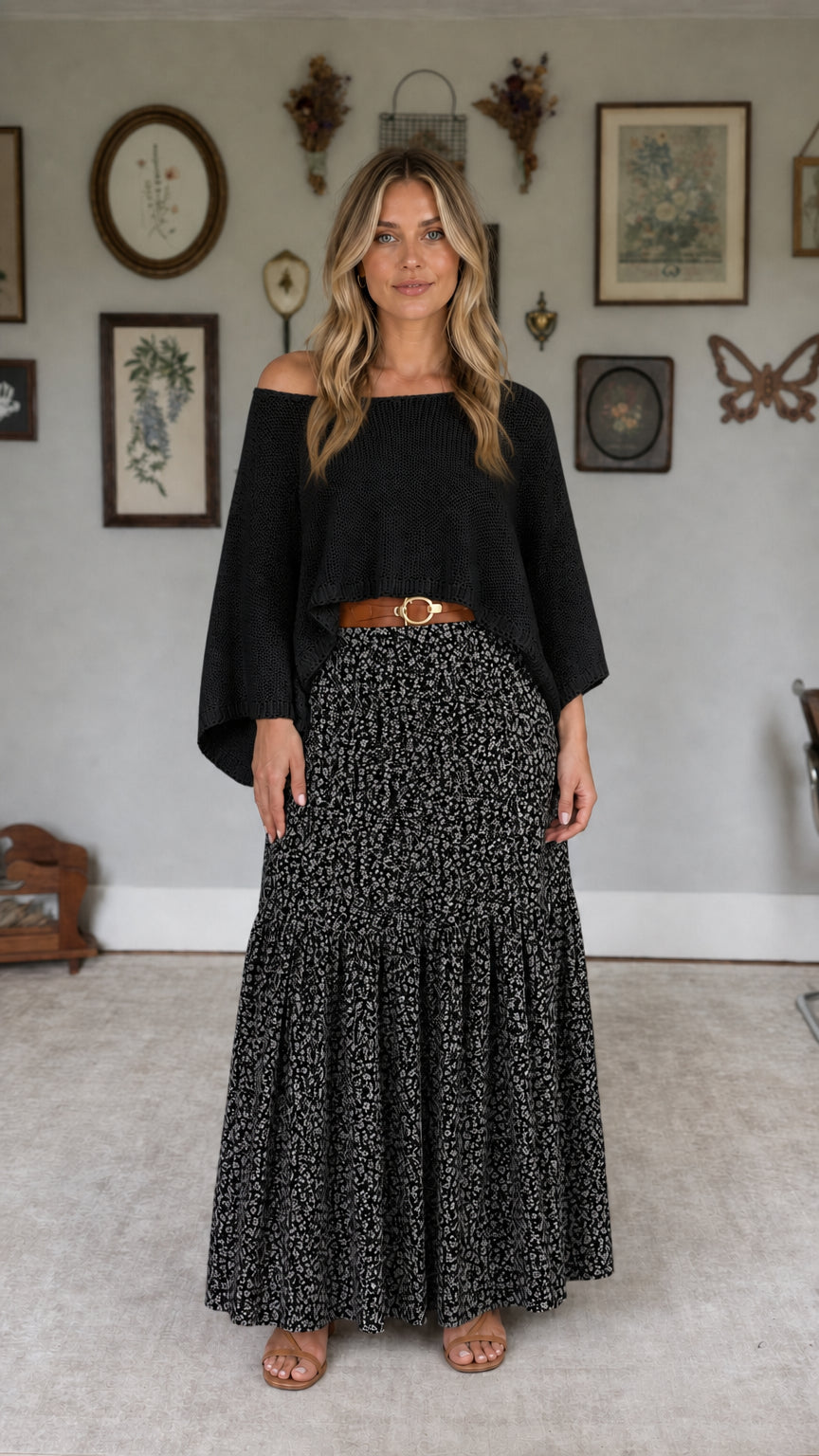 Model wearing black off-the-shoulder knit top and black floral maxi skirt set