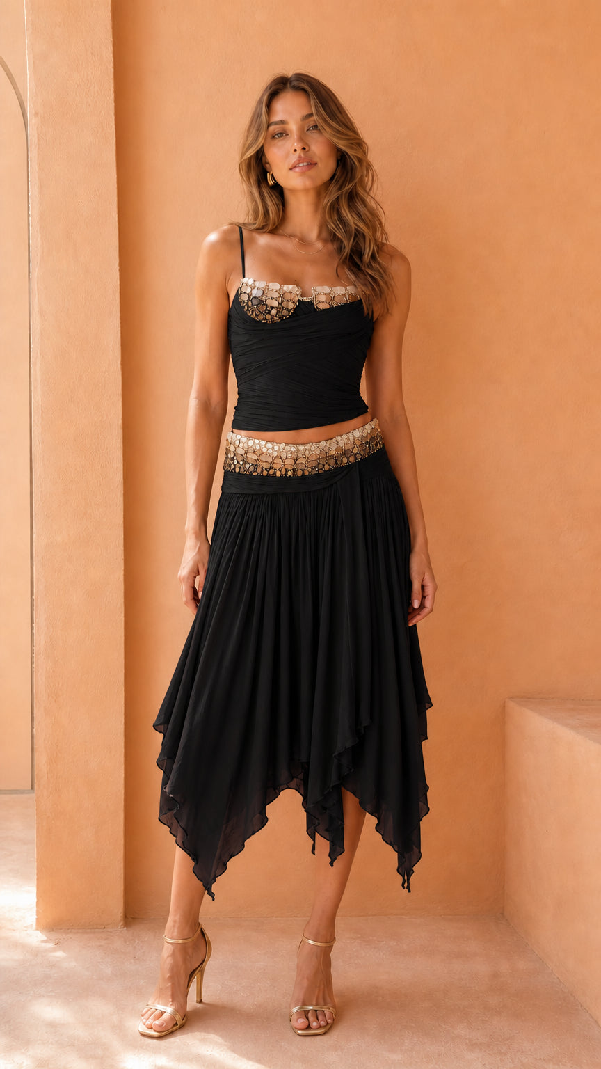 Model wearing black embellished corset top and skirt set