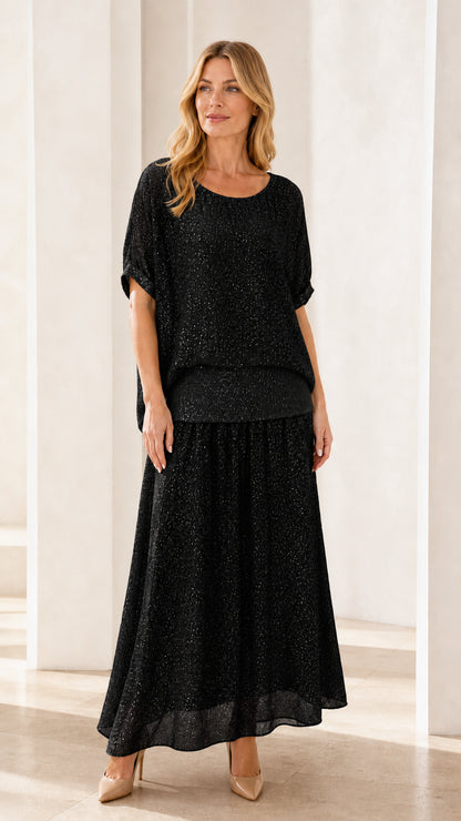 Model wearing black shimmer two-piece maxi skirt set
