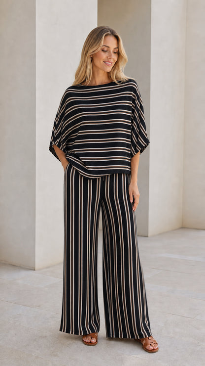 Model wearing black striped top and wide leg pants set