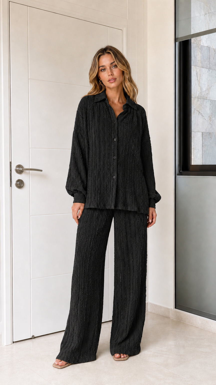 Woman wearing black textured long-sleeve shirt and matching wide-leg pants set