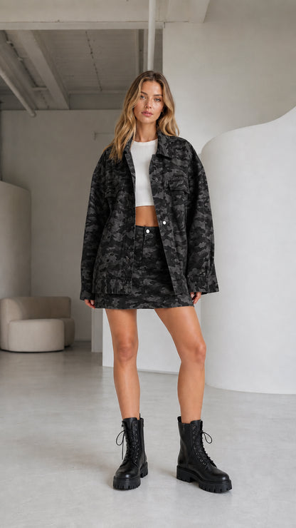 Woman wearing a black camouflage jacket and matching mini skirt with combat boots
