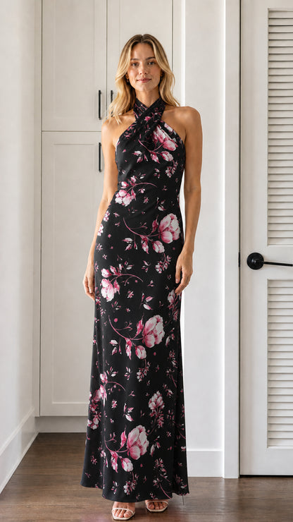 Front view of model wearing black floral halter neck maxi dress
