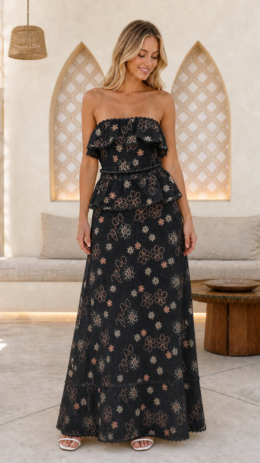 Woman wearing black floral embroidered strapless maxi dress