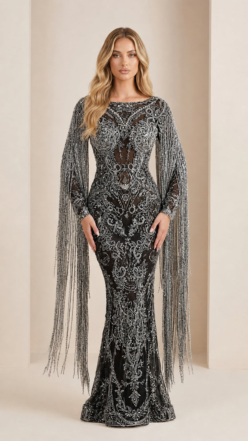 Model wearing black and silver beaded evening gown with dramatic fringe cape sleeves
