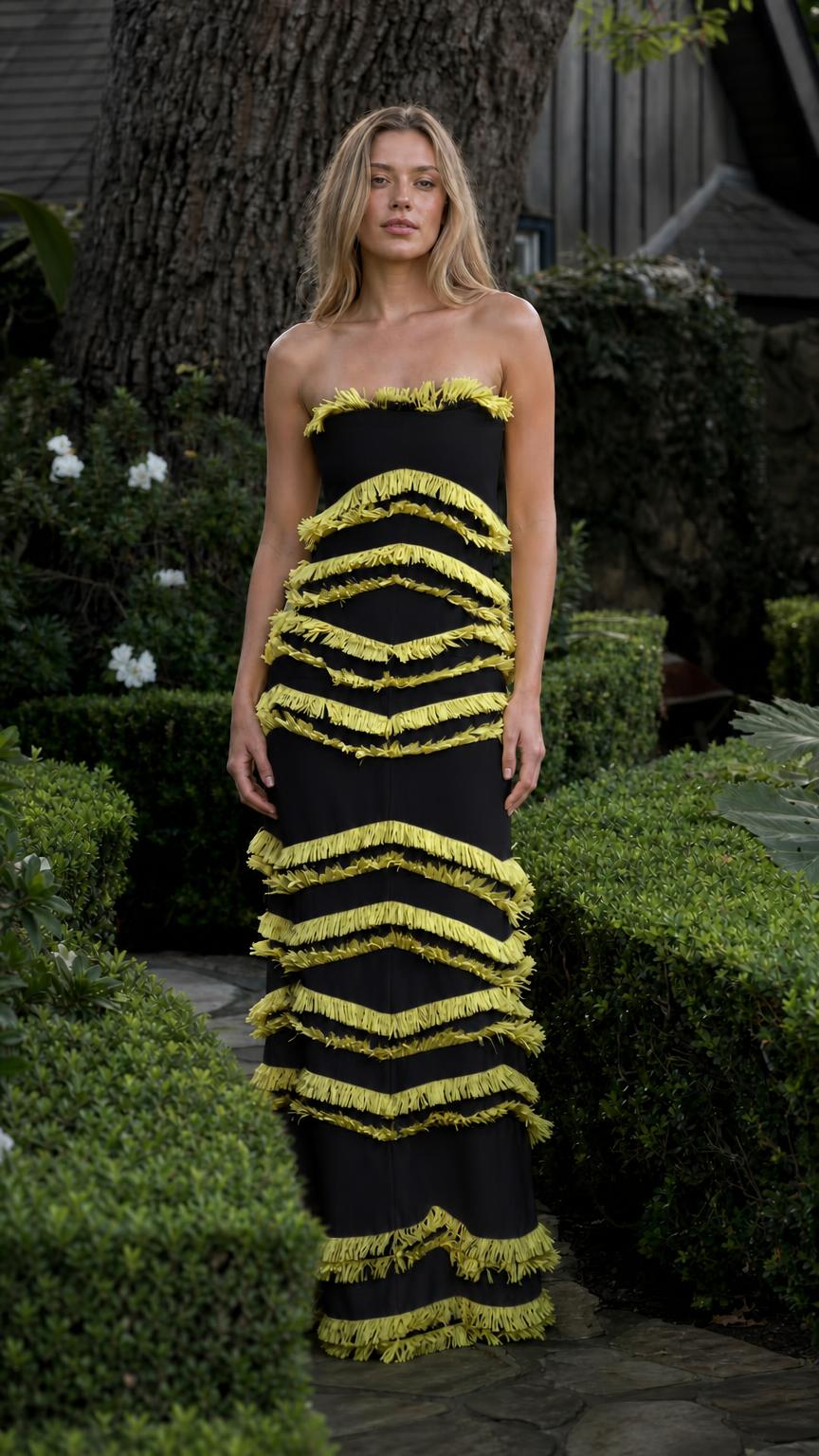 Model wearing black dress with yellow fringe tiers