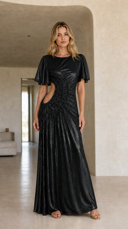 Front view of woman wearing the black color variant of the metallic cutout maxi dress