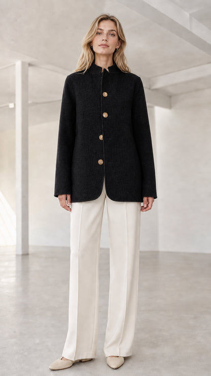 Front view of model wearing black stand collar button coat