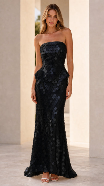 Front view of model wearing black sequin strapless peplum maxi dress