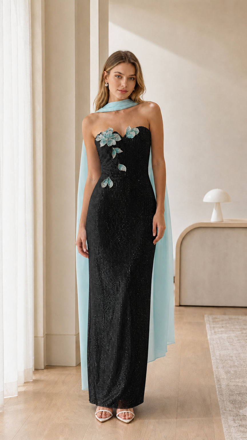 Black strapless sequin column evening gown with contrasting light blue floral accents and cape