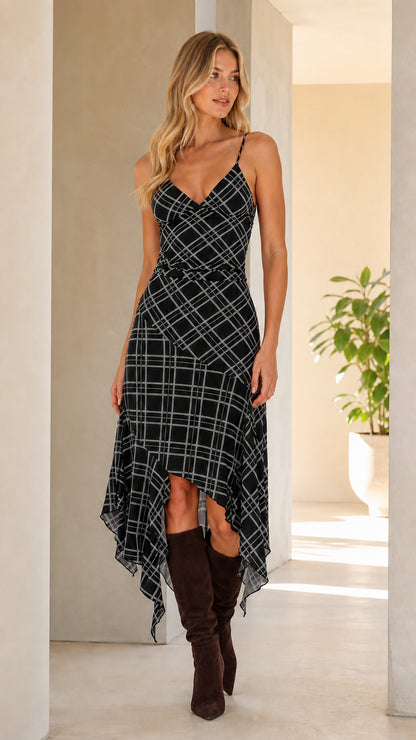 Front view of woman wearing black plaid asymmetrical cami midi dress