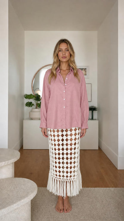 Model wearing pink long sleeve button-down shirt and patterned fringe skirt
