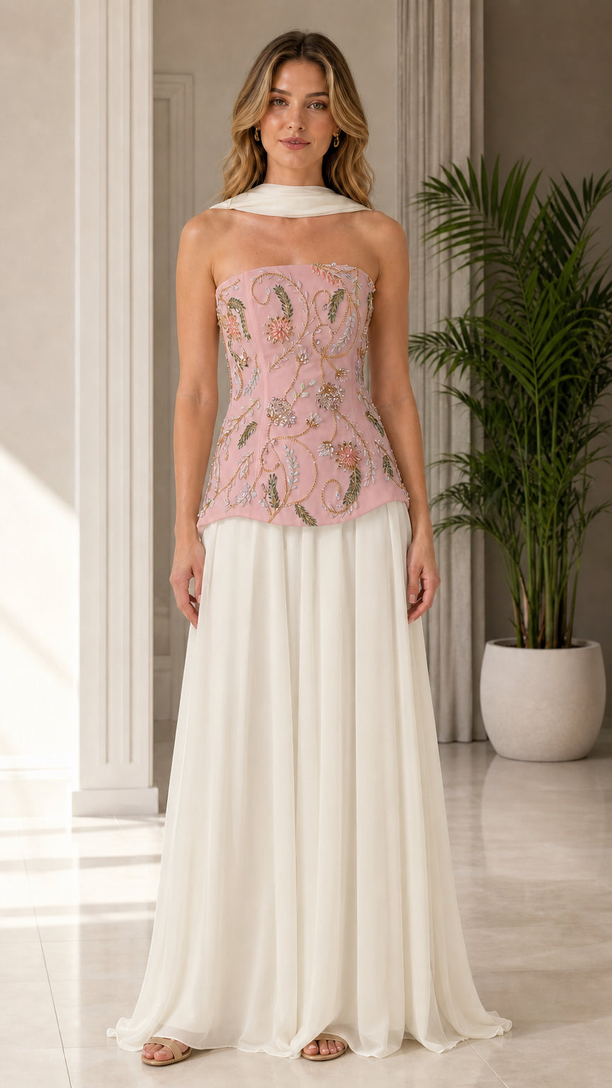 Model wearing blush pink floral beaded corset top with ivory floor-length maxi skirt