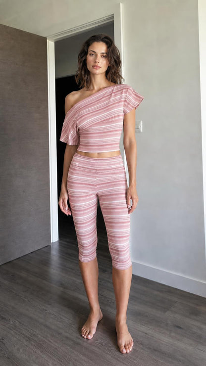 Woman wearing pink striped one-shoulder crop top and capri leggings set