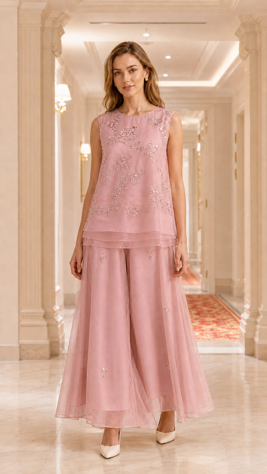 Model wearing dusty pink embroidered sleeveless tunic and wide-leg pant set