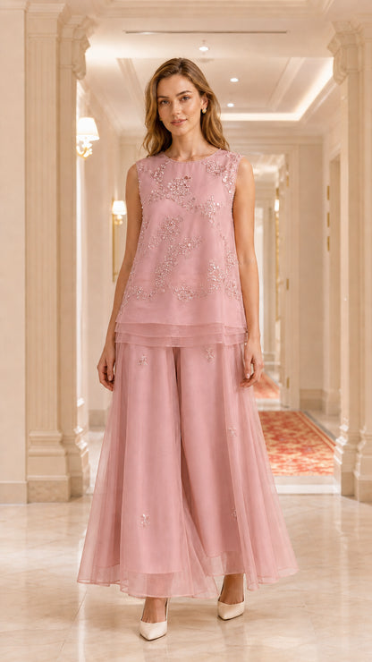 Model wearing dusty pink embroidered sleeveless tunic and wide-leg pant set