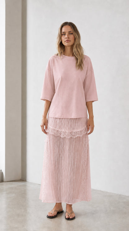 Front view of woman wearing pink relaxed tee and matching skirt set