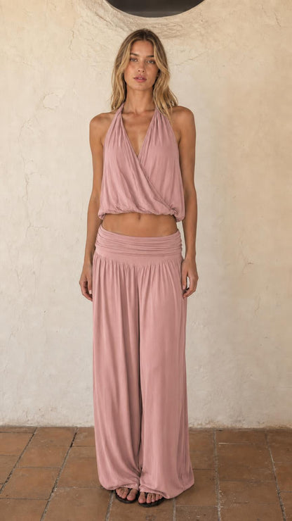 Woman wearing dusty pink halter crop top and wide leg pants set