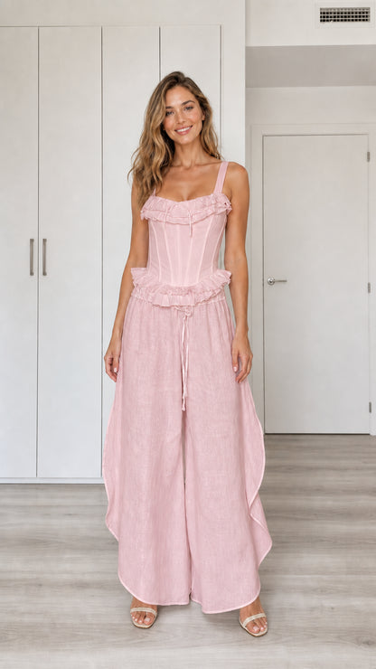 Model wearing pink ruffled corset top and wide-leg pants set