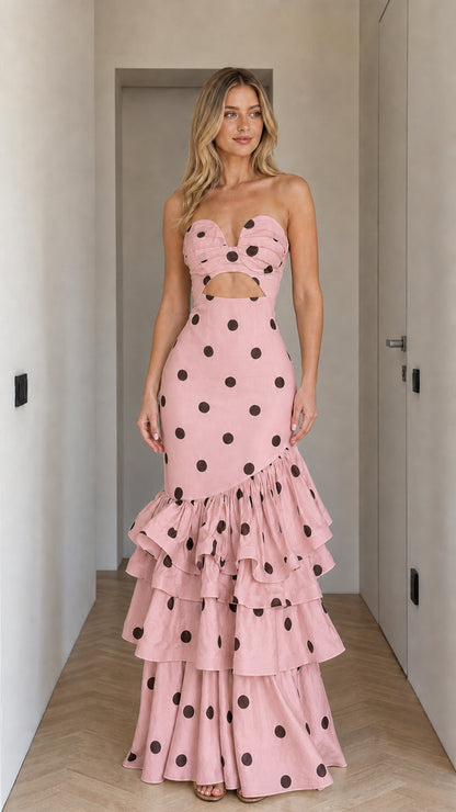 Front view of woman wearing pink polka dot strapless cutout ruffle maxi dress