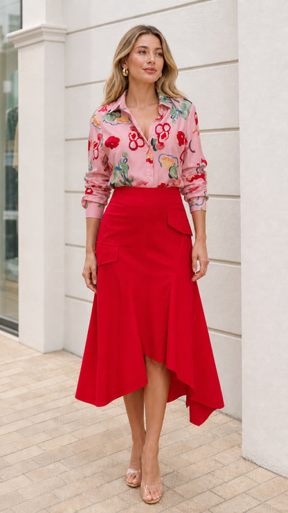 Model wearing pink floral button down shirt and red asymmetric midi skirt