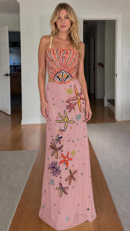 Model wearing pink color variant of beaded seashell two-piece dress
