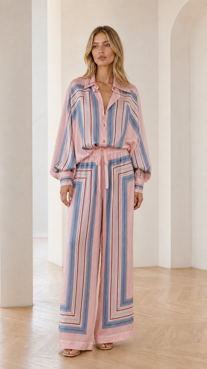 Model wearing pink geometric striped two-piece set