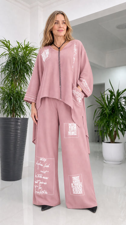 Front view of woman wearing pink typography print pant set