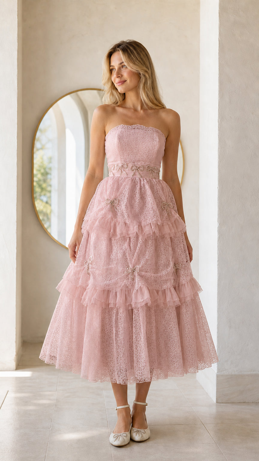 Front full view of woman wearing pink strapless tiered midi dress