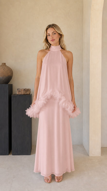 Model wearing blush pink halter maxi dress with ruffle detail