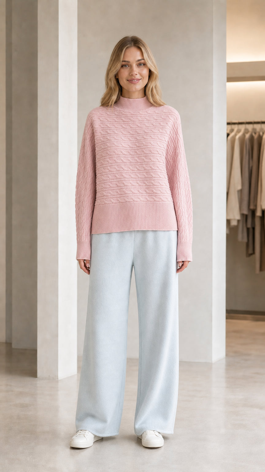 Model wearing pastel pink mock neck textured knit sweater with light blue pants