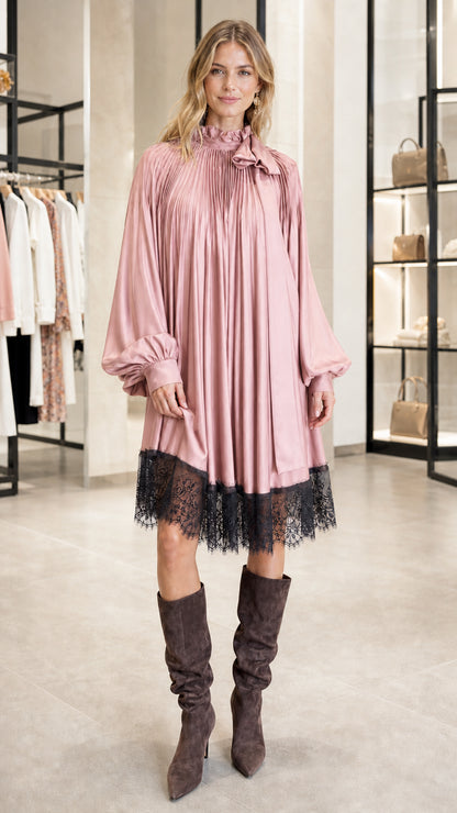 Model wearing pink pleated satin dress with lace hem