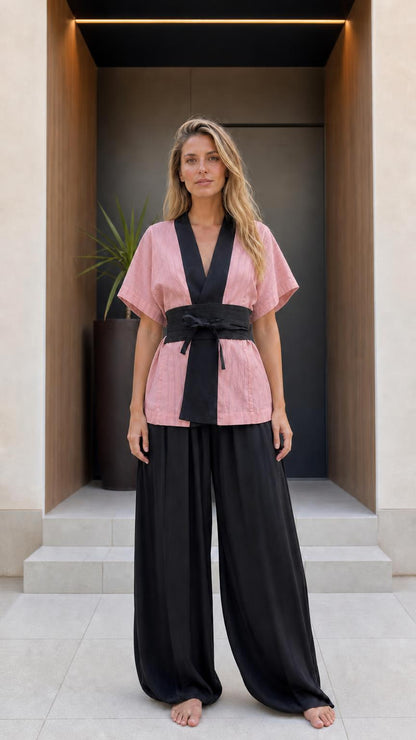 Front view of woman wearing pink kimono top and black wide-leg pants set
