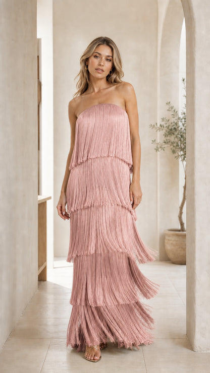 Front view of woman wearing pink strapless tiered fringe maxi dress