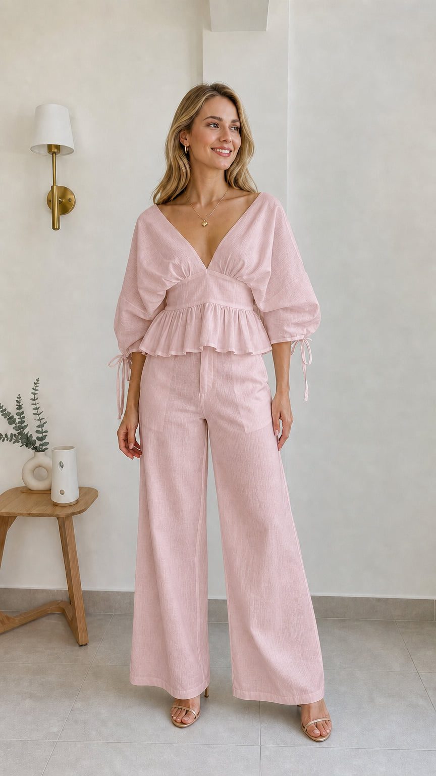 Model wearing pink two-piece peplum and wide-leg pants set