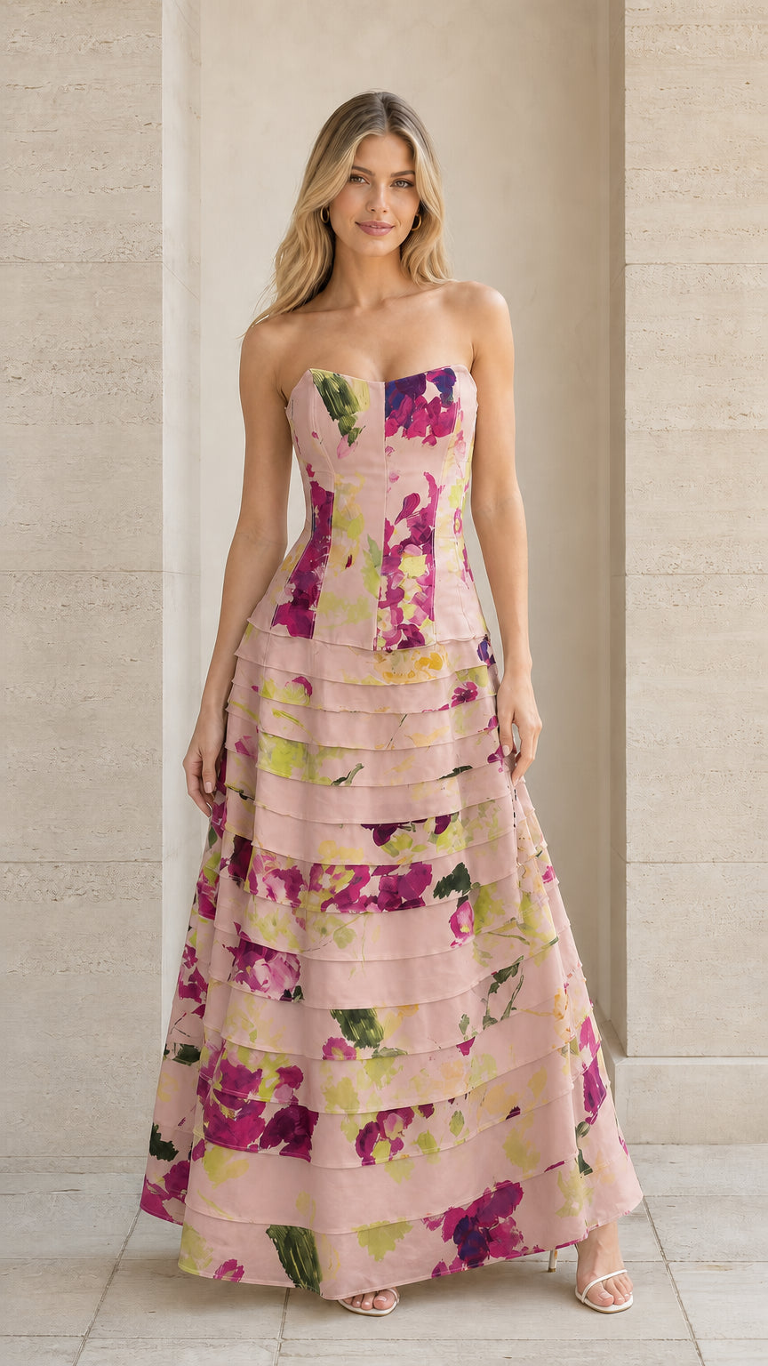 Model wearing blush pink floral strapless tiered evening gown