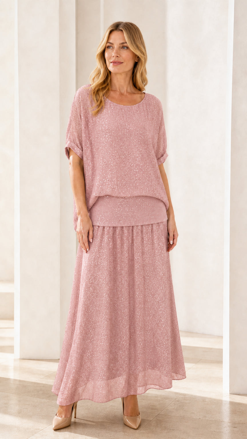 Model wearing pink shimmer two-piece maxi skirt set