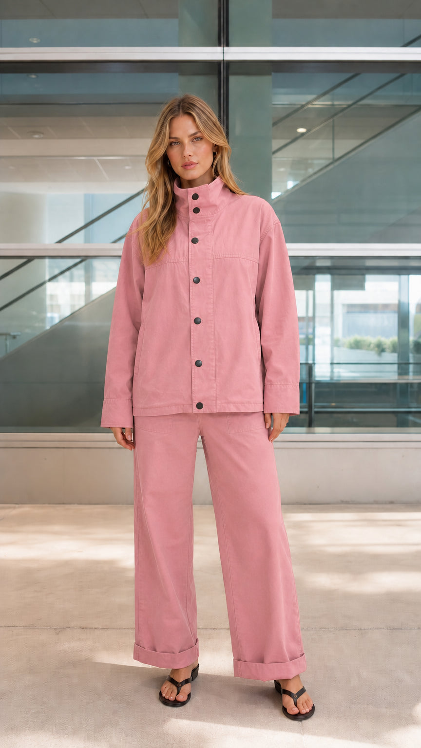 Woman wearing dusty pink two-piece utility jacket and wide-leg trousers set