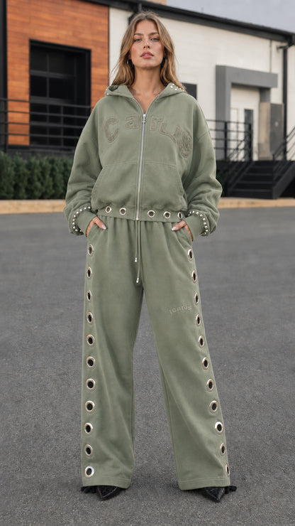 Full front view of model wearing sage green studded zip hoodie and wide-leg sweatpants set