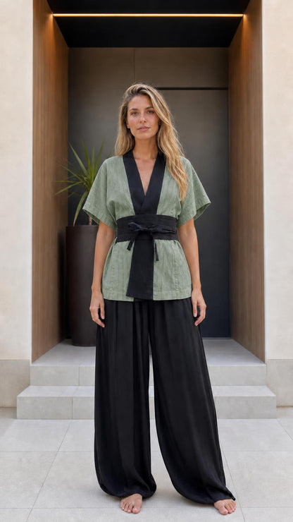 Front view of woman wearing sage green kimono top and black wide-leg pants set