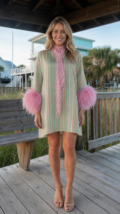 Front view of model wearing sage stripe dress with pink feather cuffs