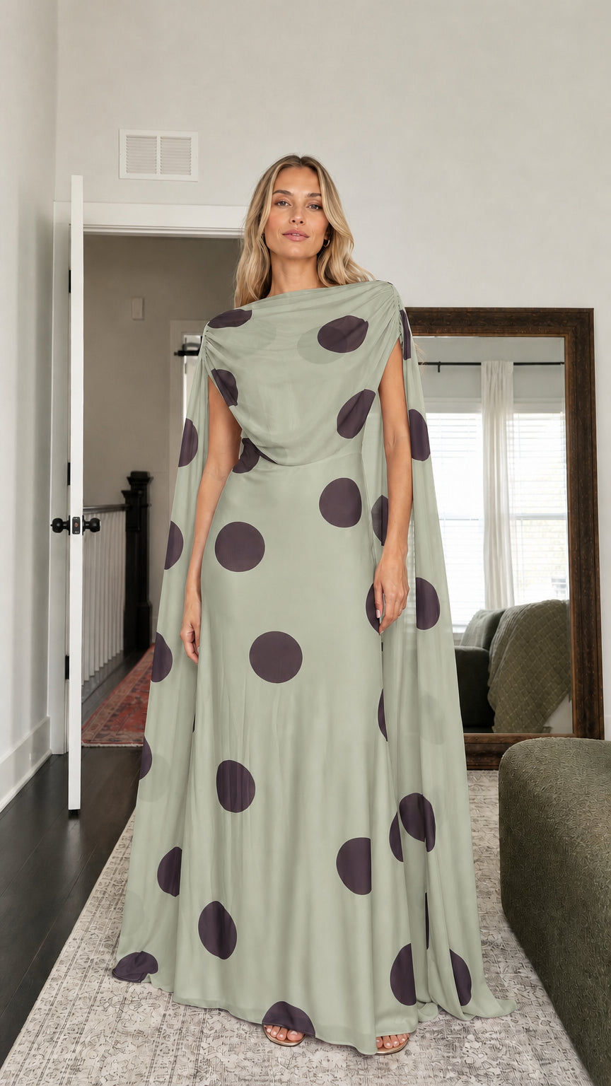 Model wearing sage green polka dot cape maxi dress