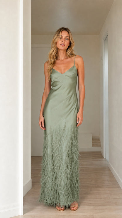 Woman wearing sage green satin feather trim maxi slip dress