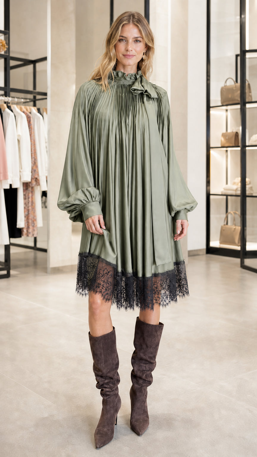 Model wearing sage green pleated satin dress with lace hem