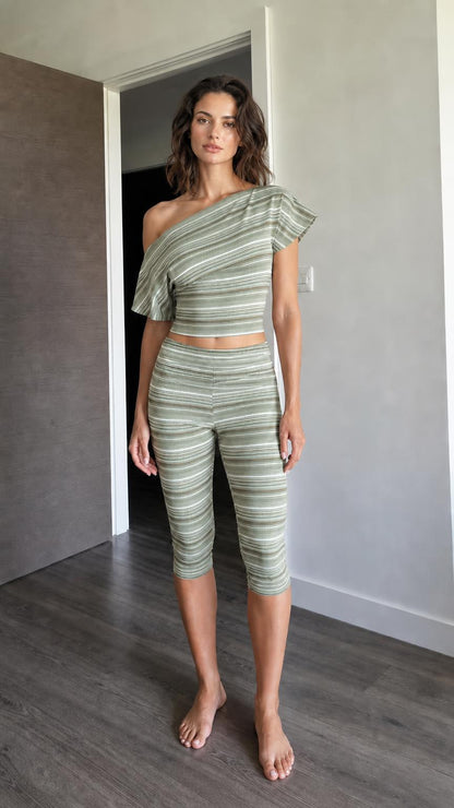 Woman wearing sage green striped one-shoulder crop top and capri leggings set