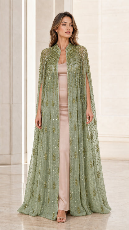 Model wearing sage green floor-length beaded cape evening gown