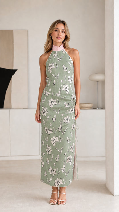 Woman wearing sage green floral halter maxi dress