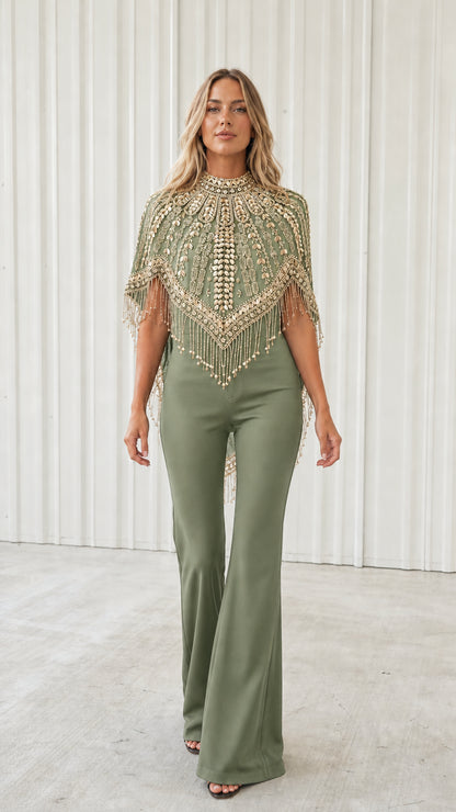 Front view of model wearing sage green beaded fringe evening capelet with green pants