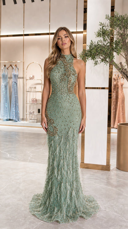 Model wearing sage green halter beaded evening gown with feather trim